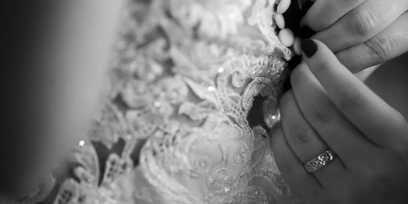A brides wedding dress getting fastened